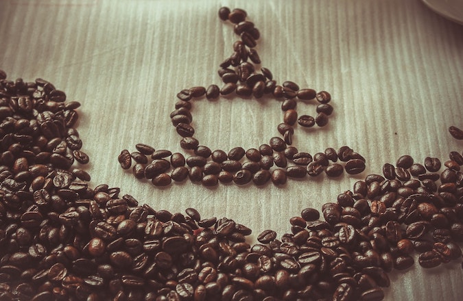 coffee beans in the shape of a coffee cup and saucer