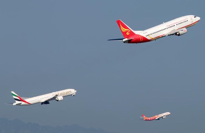 Three aircraft take off at Beijing Capital International Airport from parallel runways