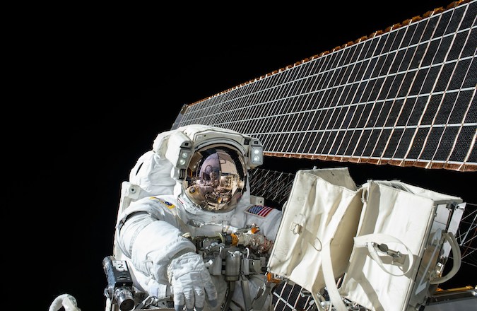 Astronaut beside satellite